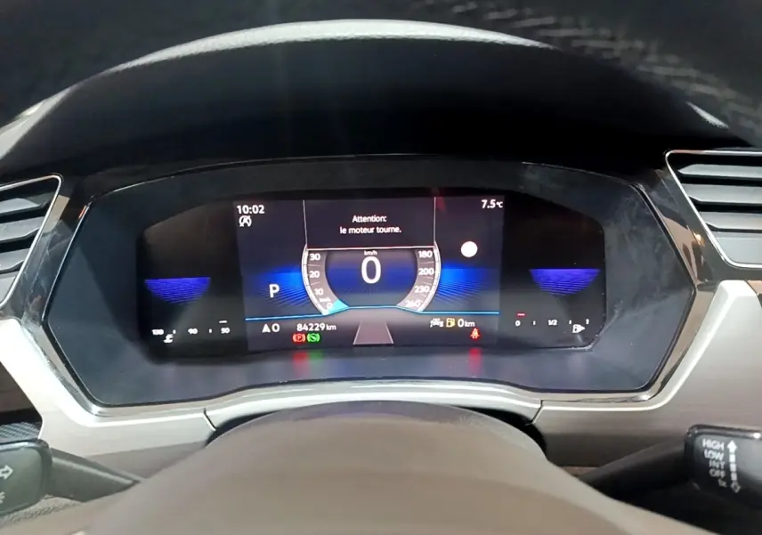 Tableau de bord numérique du Volkswagen Touran 2023 affichant la vitesse à 0 km/h et divers indicateurs.