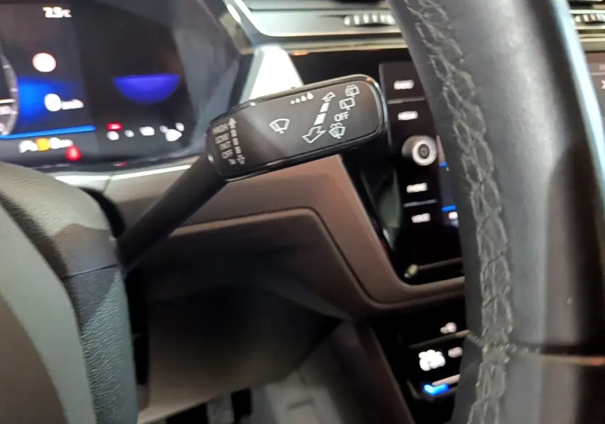 Gros plan sur la manette d’essuie-glace à gauche du volant cuir dans l’habitacle du Volkswagen Touran gris foncé 2023.