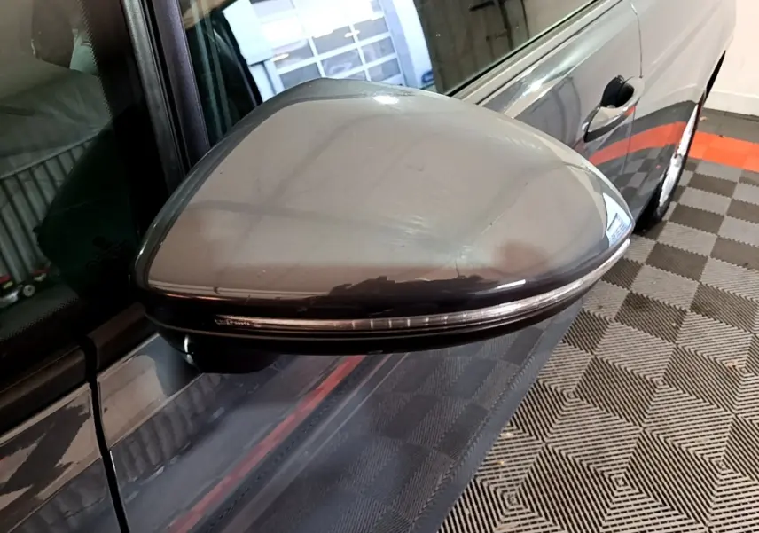 Rétroviseur droit gris foncé du Volkswagen Touran 2023, vue rapprochée sur la portière et la poignée.