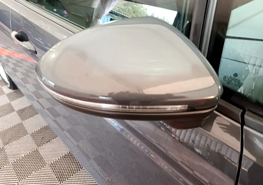 Rétroviseur droit gris foncé du Volkswagen Touran 2023 avec clignotant intégré, vue rapprochée en extérieur.