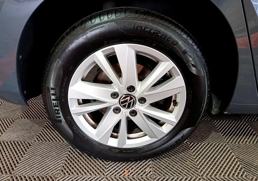 Gros plan sur la roue avant droite d'un Volkswagen Touran gris foncé avec jante alliage et pneu Pirelli.