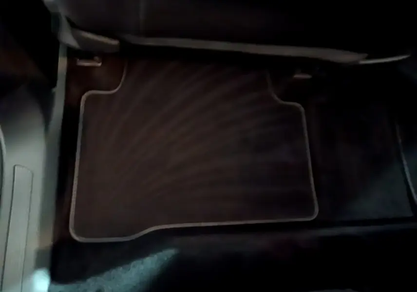 Tapis de sol noir côté passager avant dans l'habitacle du Volkswagen Touran gris foncé 2023.