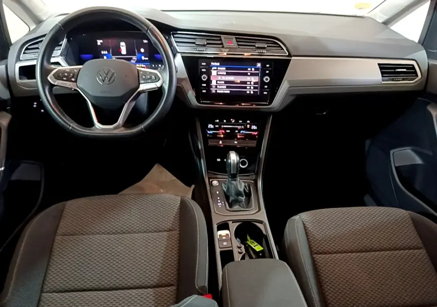 Intérieur Volkswagen Touran 2023 gris foncé, vue avant centrée sur tableau de bord et volant cuir multifonctions.