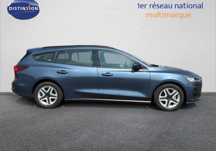 Ford Focus SW bleu foncé vue de profil côté gauche, avec barres de toit et jantes classiques 16 pouces.