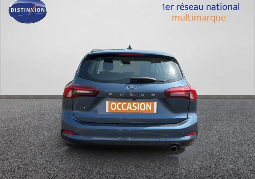 Vue arrière d'une Ford Focus SW bleu foncé de 2022 avec feux rouges et plaque "OCCASION" visible.