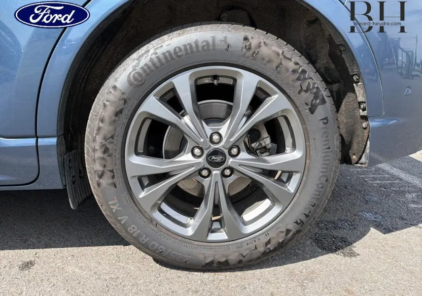 Gros plan sur la roue avant gauche du Ford Kuga bleu, jante alliage 18 pouces avec pneu Continental.