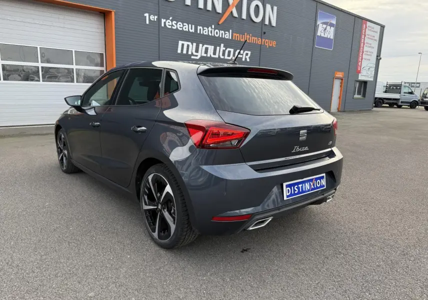 SEAT Ibiza 2024 couleur Magnetic Tech vue 3/4 arrière droit, avec jantes alliage 18 pouces et double sortie d'échappement.