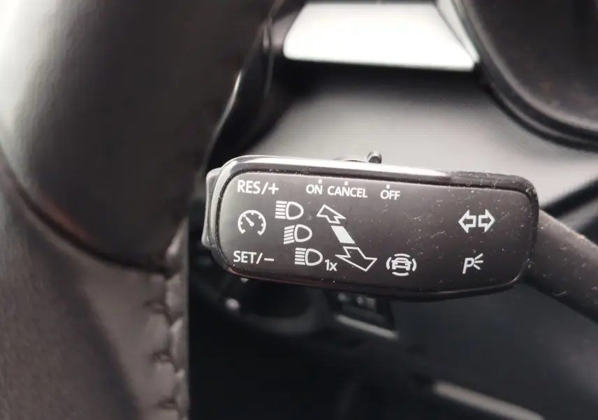 Gros plan sur la manette de commande du régulateur de vitesse et des feux dans un Skoda Fabia gris argent 2023.