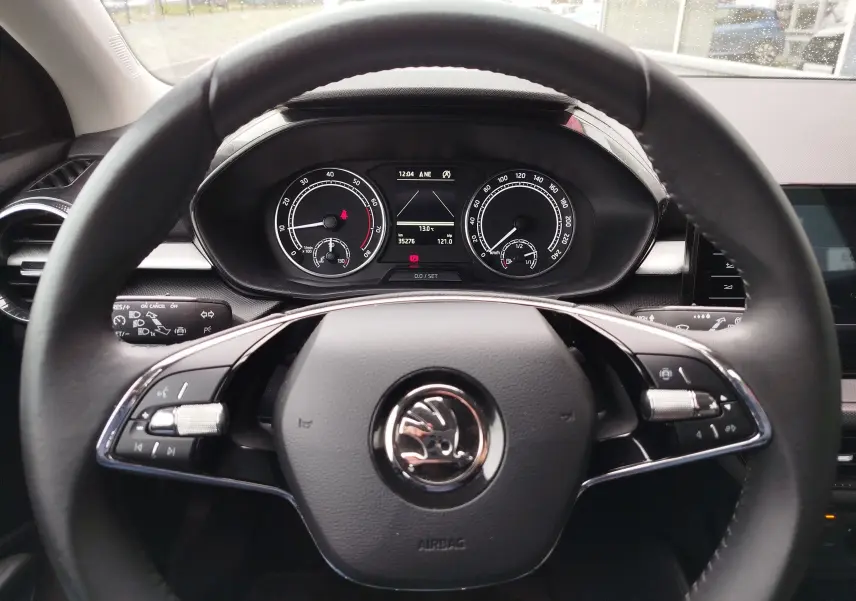 Vue intérieure centrée sur le volant noir et le tableau de bord numérique de la Skoda Fabia 2023.