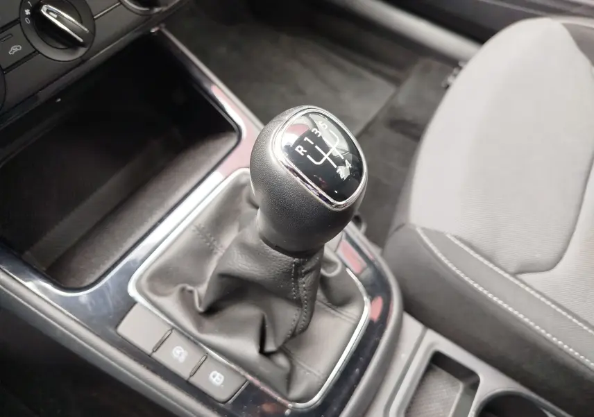 Gros plan sur le levier de vitesses manuel noir et gris de la Skoda Fabia 2023, intérieur tissu gris clair.