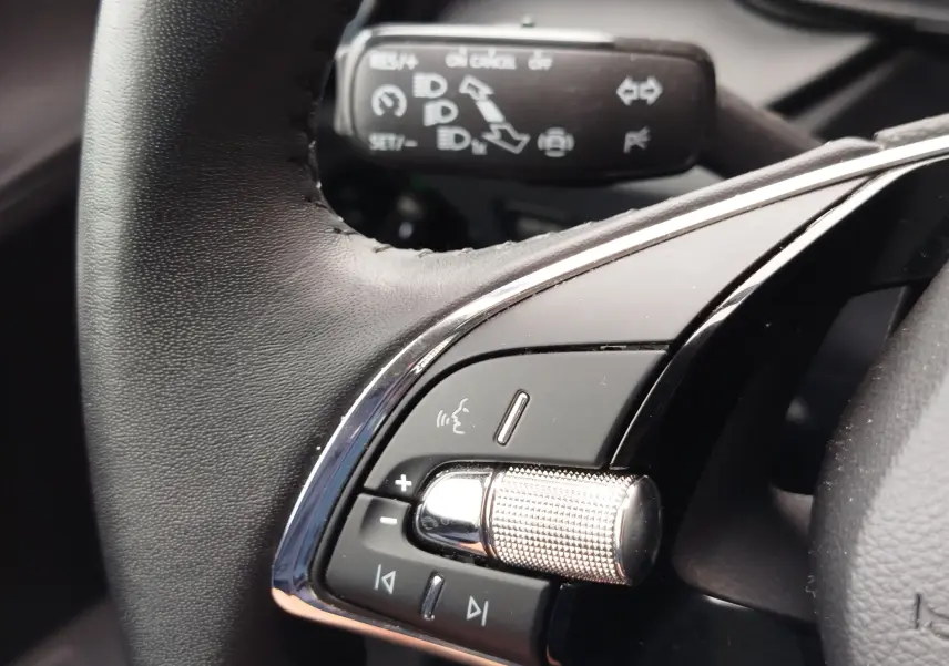 Gros plan sur les commandes au volant côté gauche d'une Skoda Fabia 2023, avec molette et boutons multifonctions.