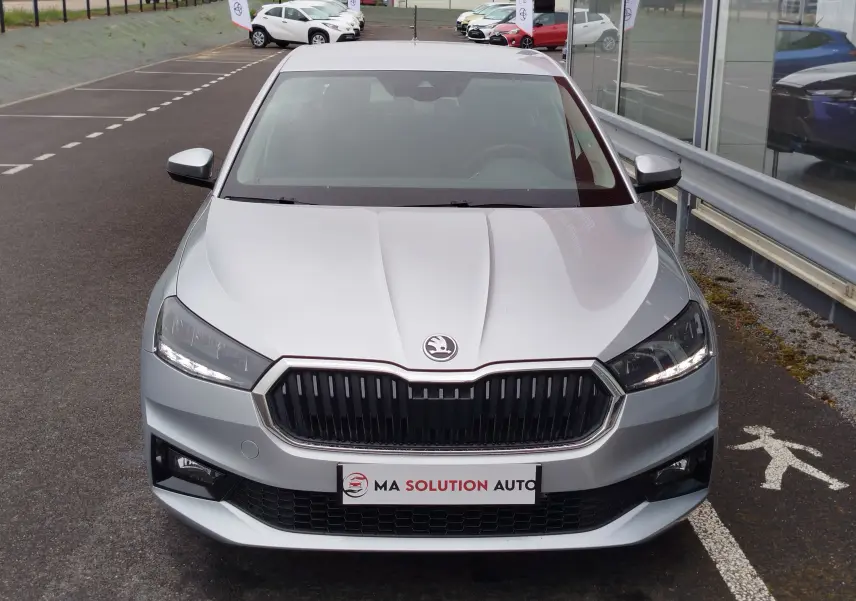 Vue avant d'une Skoda Fabia 2023 gris argent métallisé, avec calandre noire et phares LED allumés.