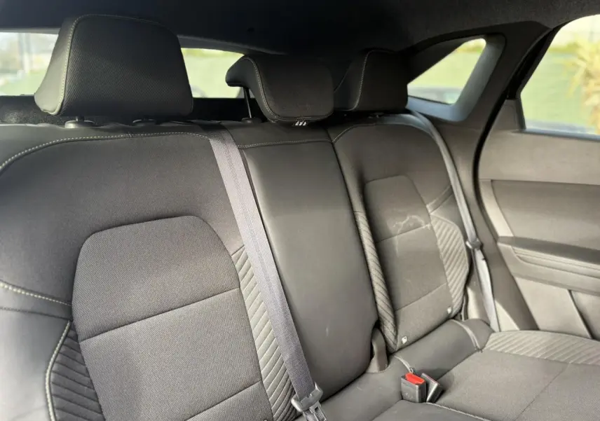 Vue intérieure arrière côté droit montrant la banquette noire étoilée avec appuie-têtes et ceinture de sécurité.