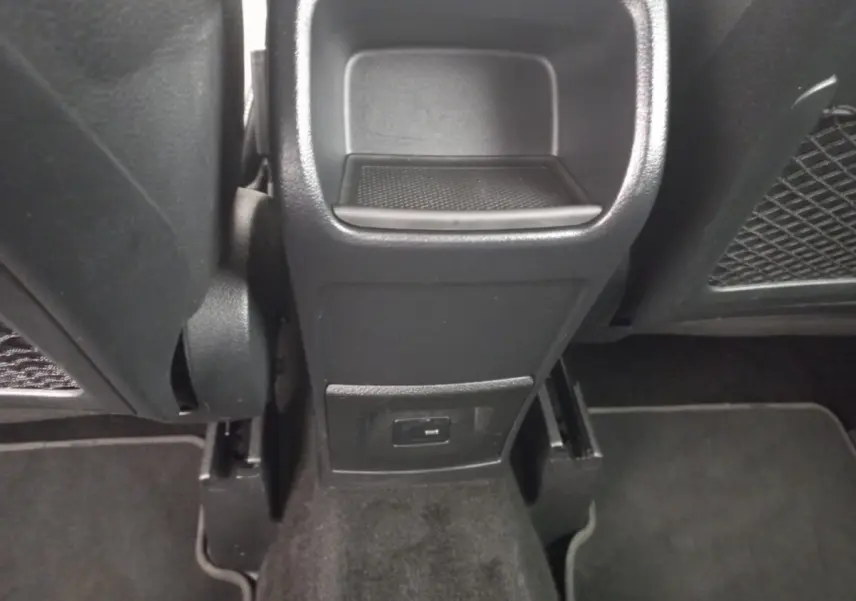 Vue rapprochée de la console centrale arrière noire de la Mercedes Classe A Berline A 200 AMG Line avec prise USB visible.