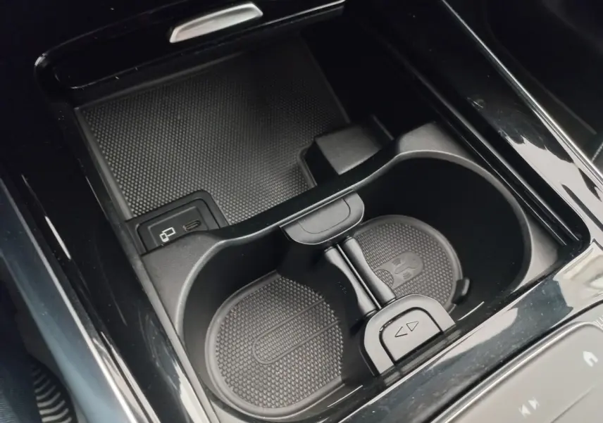 Gros plan sur le porte-gobelets et la zone de recharge sans fil intérieure de la Mercedes Classe A A 200 AMG Line noire.