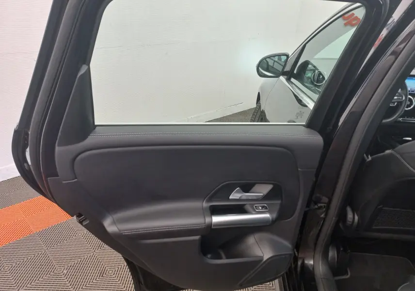 Vue intérieure sur la porte arrière gauche noire d’une Mercedes Classe A Berline A 200 AMG Line 2021.
