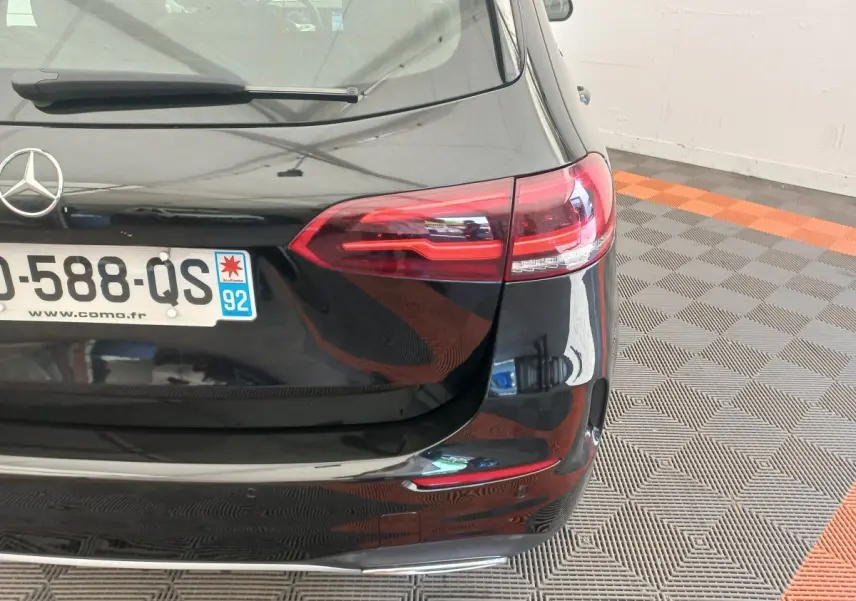 Vue arrière droite d'une Mercedes Classe A Berline A 200 AMG Line noire avec feux LED et plaque d'immatriculation française.