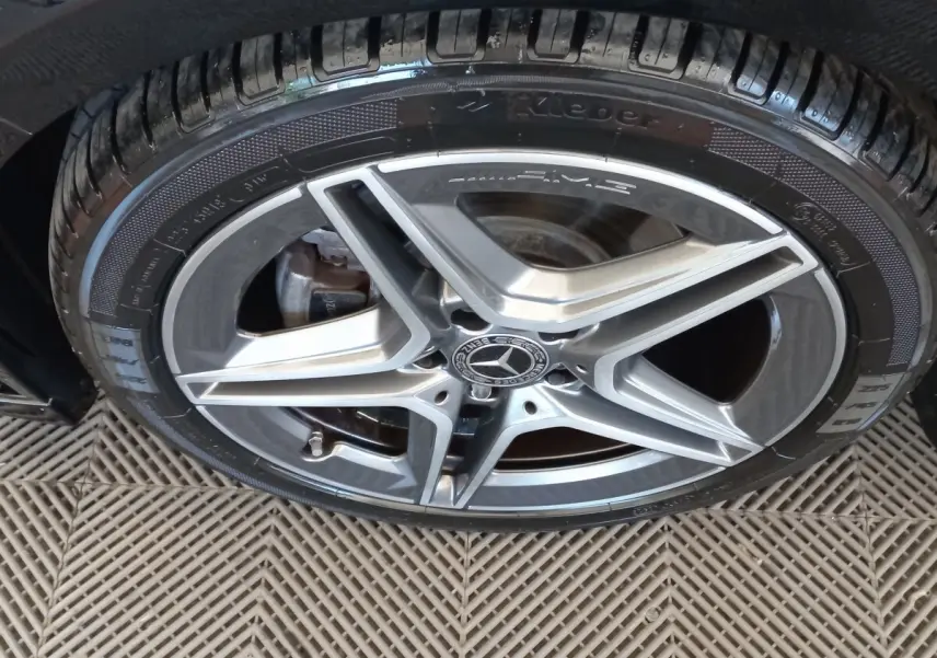 Gros plan sur la jante AMG argentée et le pneu noir d'une Mercedes Classe A Berline A 200 AMG Line 2021.