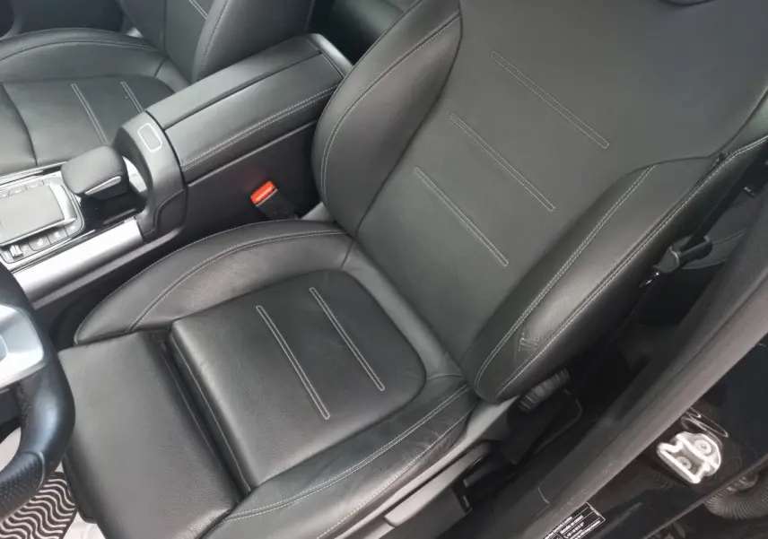 Gros plan sur le siège avant gauche en cuir noir avec surpiqûres blanches de la Mercedes Classe A Berline A 200 AMG Line 2021.