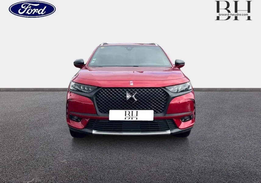 Vue frontale d'un DS7 Crossback rouge Absolu avec calandre noire et toit ouvrant panoramique visible.