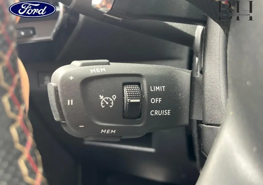 Gros plan sur la commande de régulateur de vitesse d'une DS7 Crossback rouge, avec molette et inscriptions LIMIT OFF CRUISE.