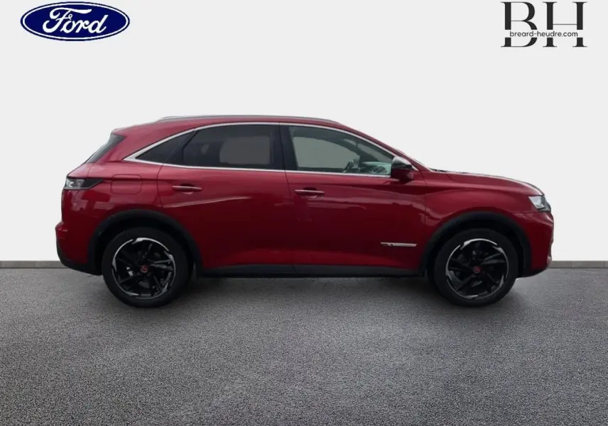 Vue de profil côté gauche du DS7 Crossback rouge Absolu avec jantes noires et toit ouvrant panoramique visible.