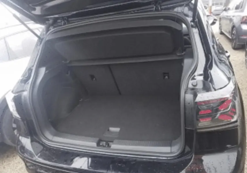 Vue arrière du Volkswagen T-Cross noir métal 2025 avec coffre ouvert, mettant en valeur ses feux arrière distinctifs.