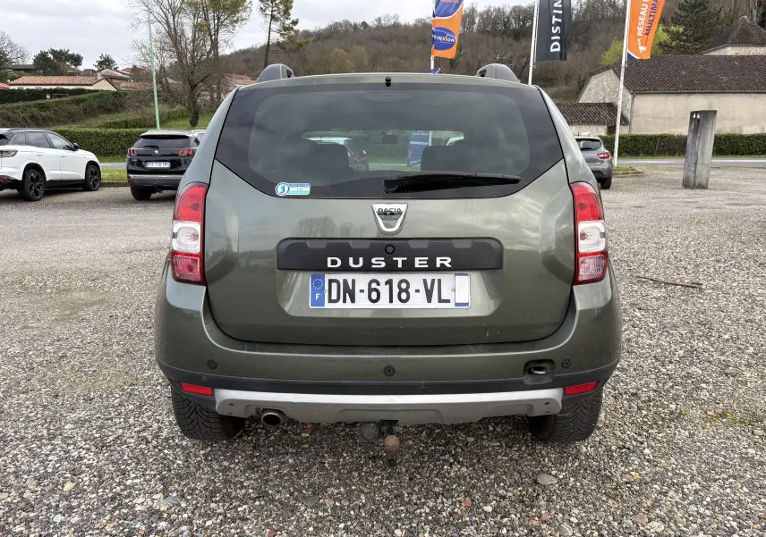 Vue arrière d'un Dacia Duster 1.5 DCI 110 vert foncé de 2014 avec attelage et plaque d'immatriculation française.