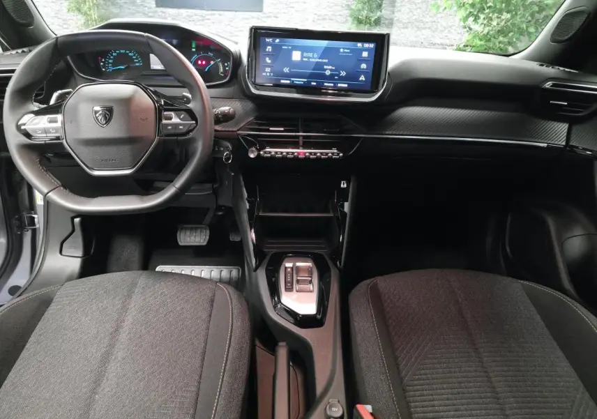 Intérieur Peugeot 2008 2025 vu de face, tableau de bord noir avec écran tactile 10 pouces et volant compact cuir.