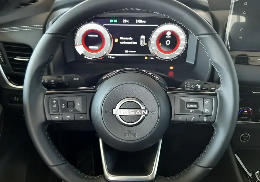 Vue rapprochée du volant noir du Nissan Qashqai 2022 avec tableau de bord digital affichant les compteurs.