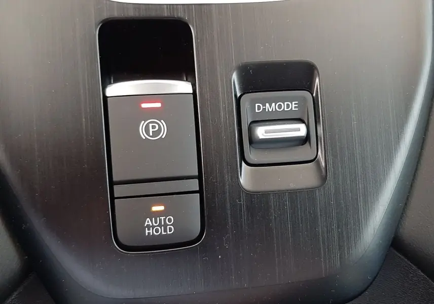 Gros plan sur les commandes D-MODE et frein à main électronique du Nissan Qashqai blanc lunaire 2022.