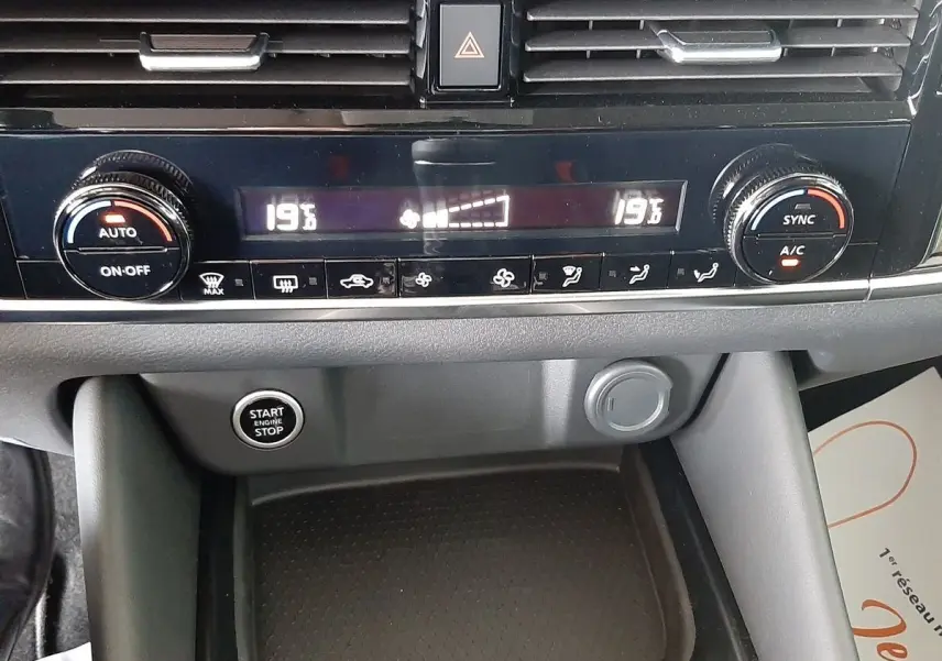 Tableau de bord du Nissan Qashqai 2022 montrant la climatisation digitale et le bouton start/stop en noir et gris.