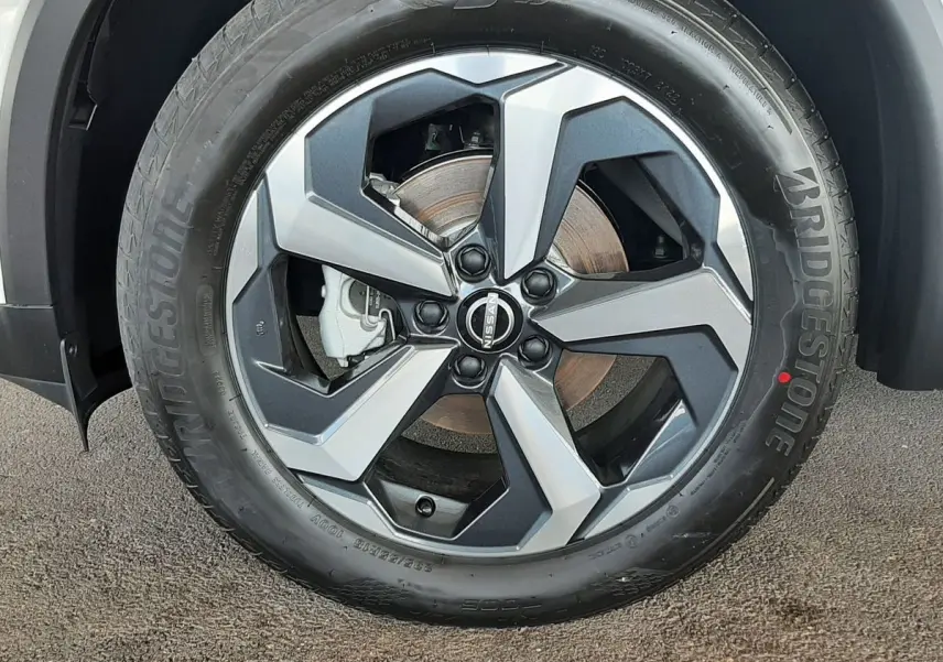Gros plan sur la jante alliage bicolore et pneu Bridgestone du Nissan Qashqai blanc lunaire 2022.
