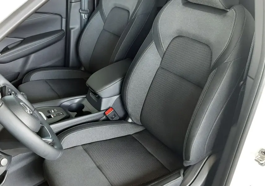 Vue intérieure côté conducteur du Nissan Qashqai blanc lunaire 2022, sièges tissu gris foncé avec surpiqûres claires.