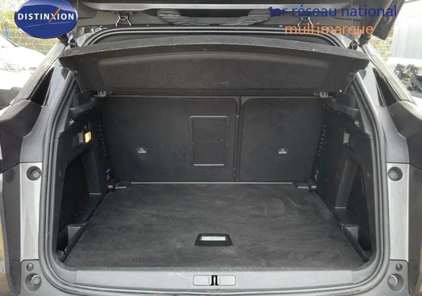 Coffre ouvert d'un Peugeot 3008 gris platinium métal, vue arrière montrant l'espace de chargement vide et propre.