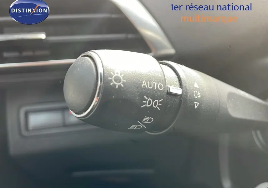 Gros plan sur la commande des phares du Peugeot 3008 gris platinium, intérieur moderne et épuré.