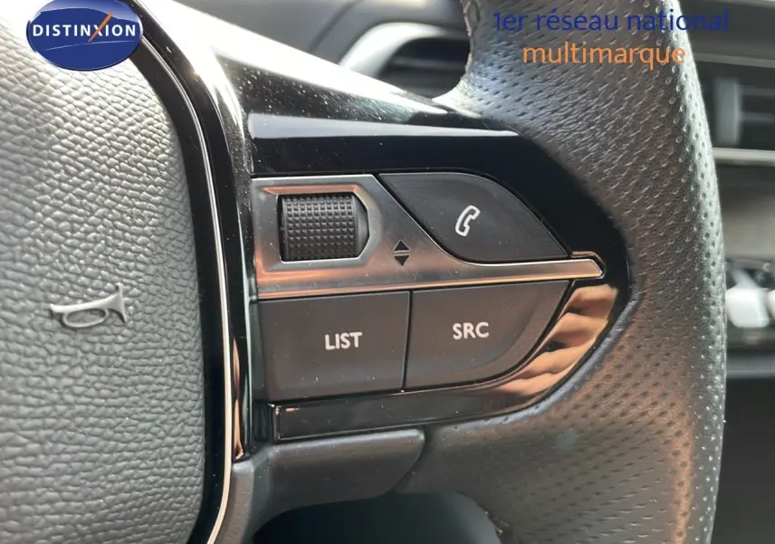 Gros plan sur les commandes gauche du volant en cuir noir du Peugeot 3008 gris platinium 2023.