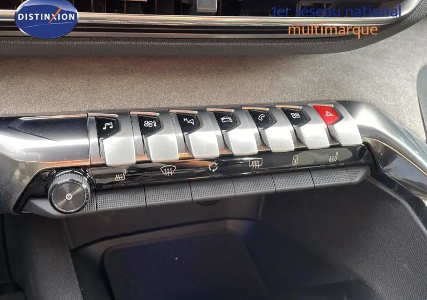 Gros plan sur la rangée de commandes métalliques et boutons noirs du tableau de bord du Peugeot 3008 gris platinium de 2023.