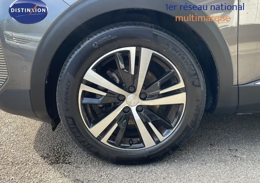 Gros plan sur la roue avant droite du Peugeot 3008 gris platinium avec jante alliage bicolore et pneu Michelin.