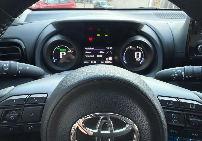 Vue intérieure centrée sur le volant Toyota et le tableau de bord numérique de la Yaris Hybride 2021.