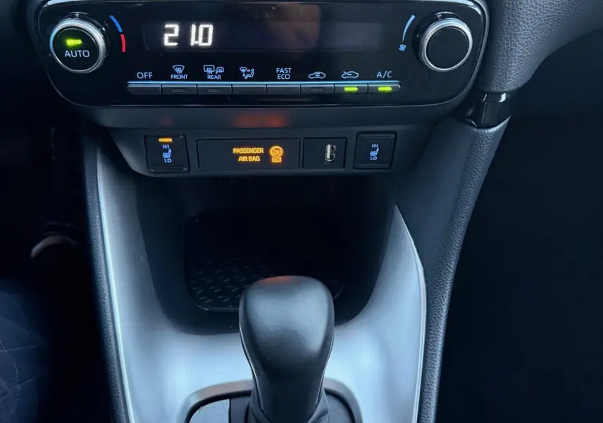 Vue rapprochée de la console centrale de la Toyota Yaris Hybride 2021, montrant la commande de climatisation et le levier de boîte automatique.