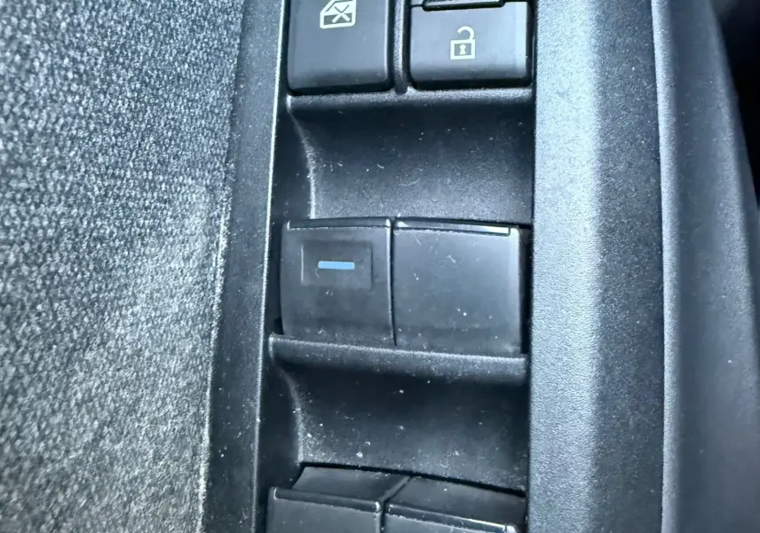 Gros plan sur les commandes de verrouillage et lève-vitres côté conducteur d'une Toyota Yaris Hybride bleu métal 2021.