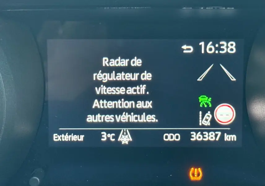 Affichage du tableau de bord de la Toyota Yaris Hybride bleu métal, montrant le régulateur de vitesse actif et l'odomètre à 36387 km.
