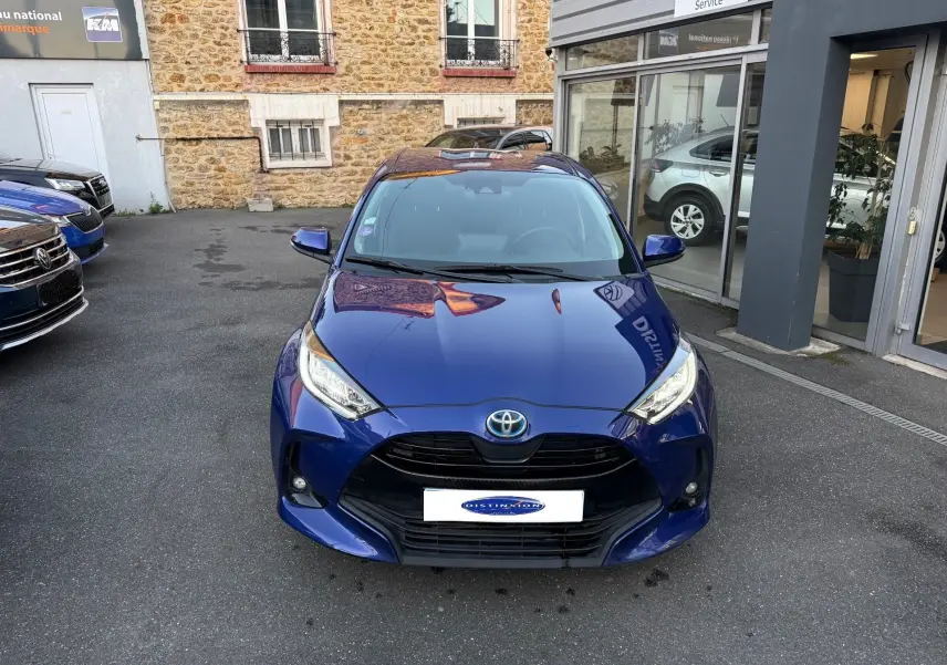 Toyota Yaris Hybride Design 116h bleu métal vue de face, mettant en valeur sa calandre noire et ses phares LED fins.