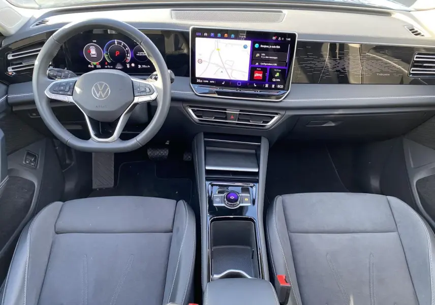 Vue intérieure avant du Volkswagen Tiguan 1.5 eHybrid 2025, tableau de bord numérique et écran tactile central visibles.