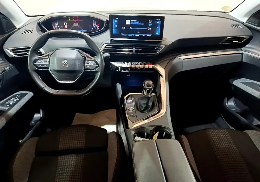 Vue intérieure avant du Peugeot 3008 2022 noir, tableau de bord numérique, écran tactile central et volant cuir multifonctions.