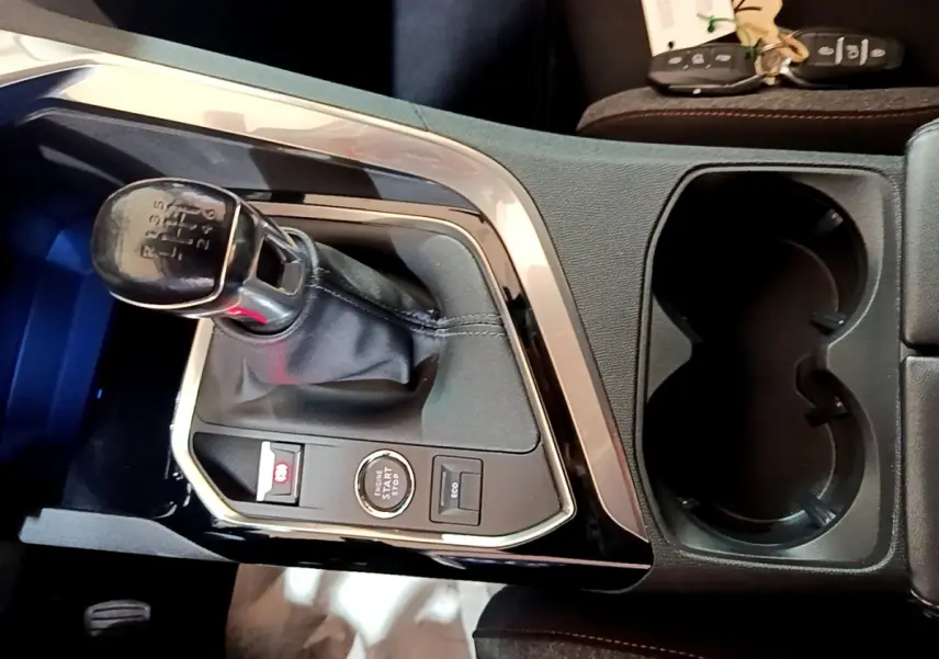 Vue rapprochée de la console centrale noire du Peugeot 3008 2022 avec levier de vitesse manuel et bouton démarrage.