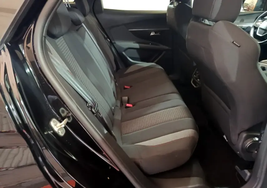 Vue intérieure côté gauche des sièges arrière noirs du Peugeot 3008 2022, tissu avec motifs et ceintures visibles.