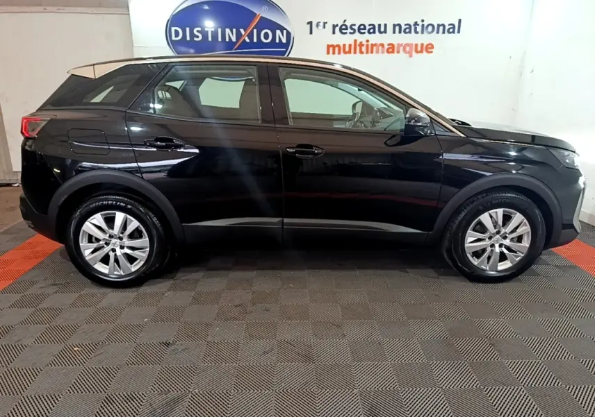 Vue latérale droite d'un Peugeot 3008 noir 2022 stationné en intérieur avec jantes alliage et toit beige clair.