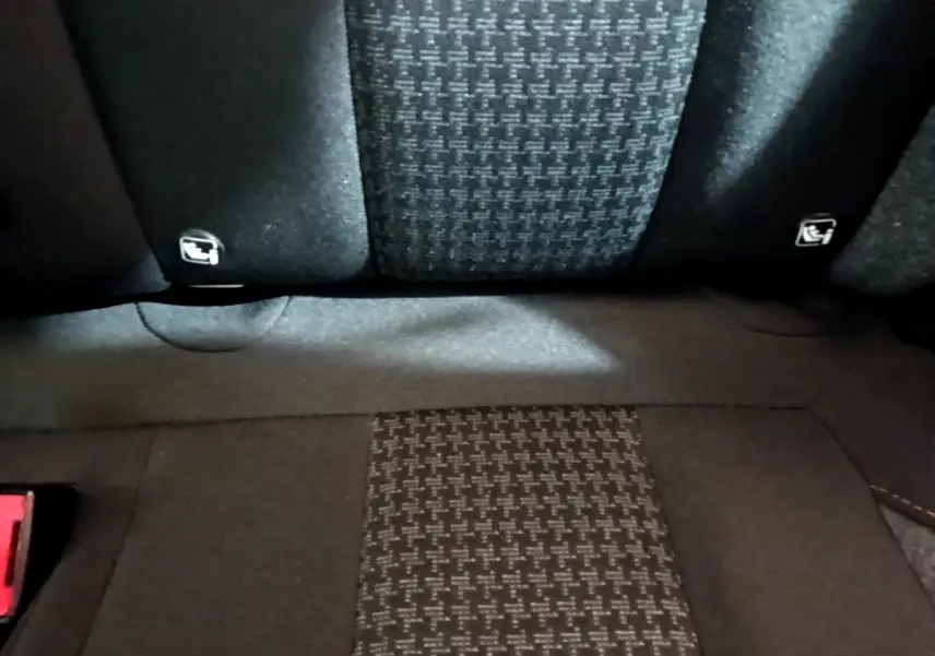 Gros plan sur la banquette arrière en tissu noir à motifs, avec fixation Isofix visible sur un Peugeot 3008 2022.
